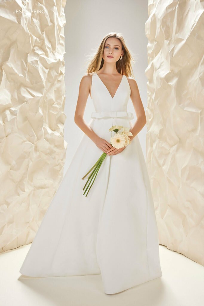 Foto de vestido de novia con lazo en la cintura y ramo de flores amarilla de Jesus Peiro