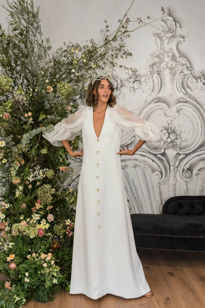 Foto de vestido de novia de Alicia Rueda con mangas abullonadas y botones joya en el centro