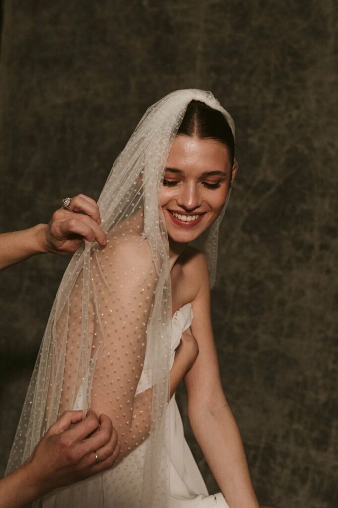 Foto de novia con velo de plumetti en color blanco roto y purpurina de Sophie et Voila
