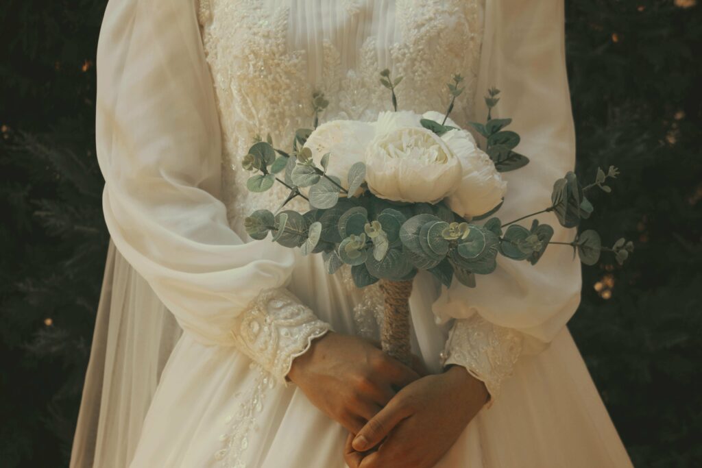 Foto de un vestido de novia con mangas holgadas y ramo de flores blancas